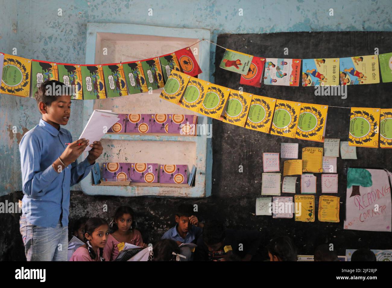 A child recites from a notebook during class at government school in rural area of Himachal Pradesh. Children engage in class activities at a government school in Baddi, a rural area in Himachal Pradesh. Stock Photo