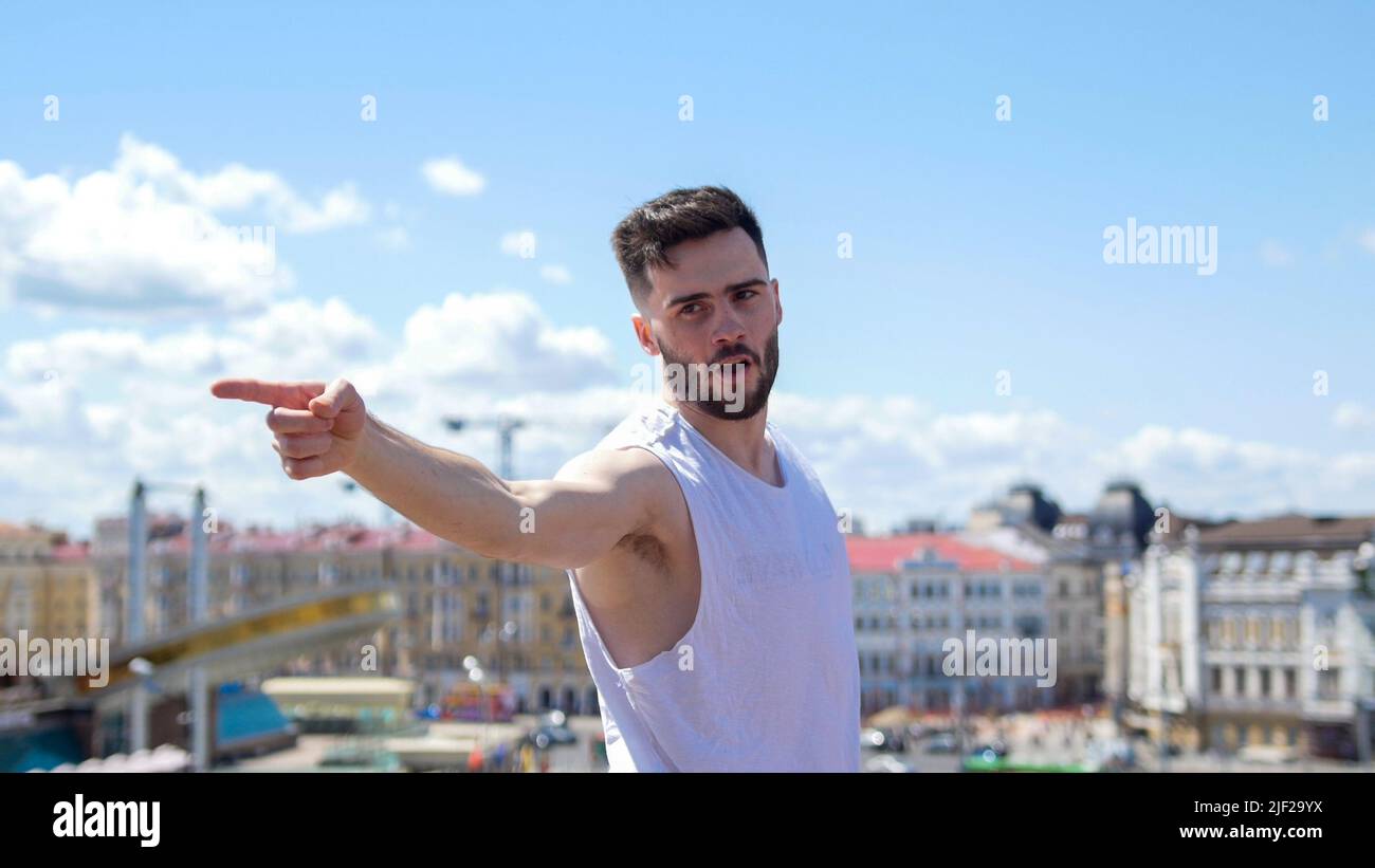 Young emotional man freestyle dancing on the stand - pointing at something Stock Photo