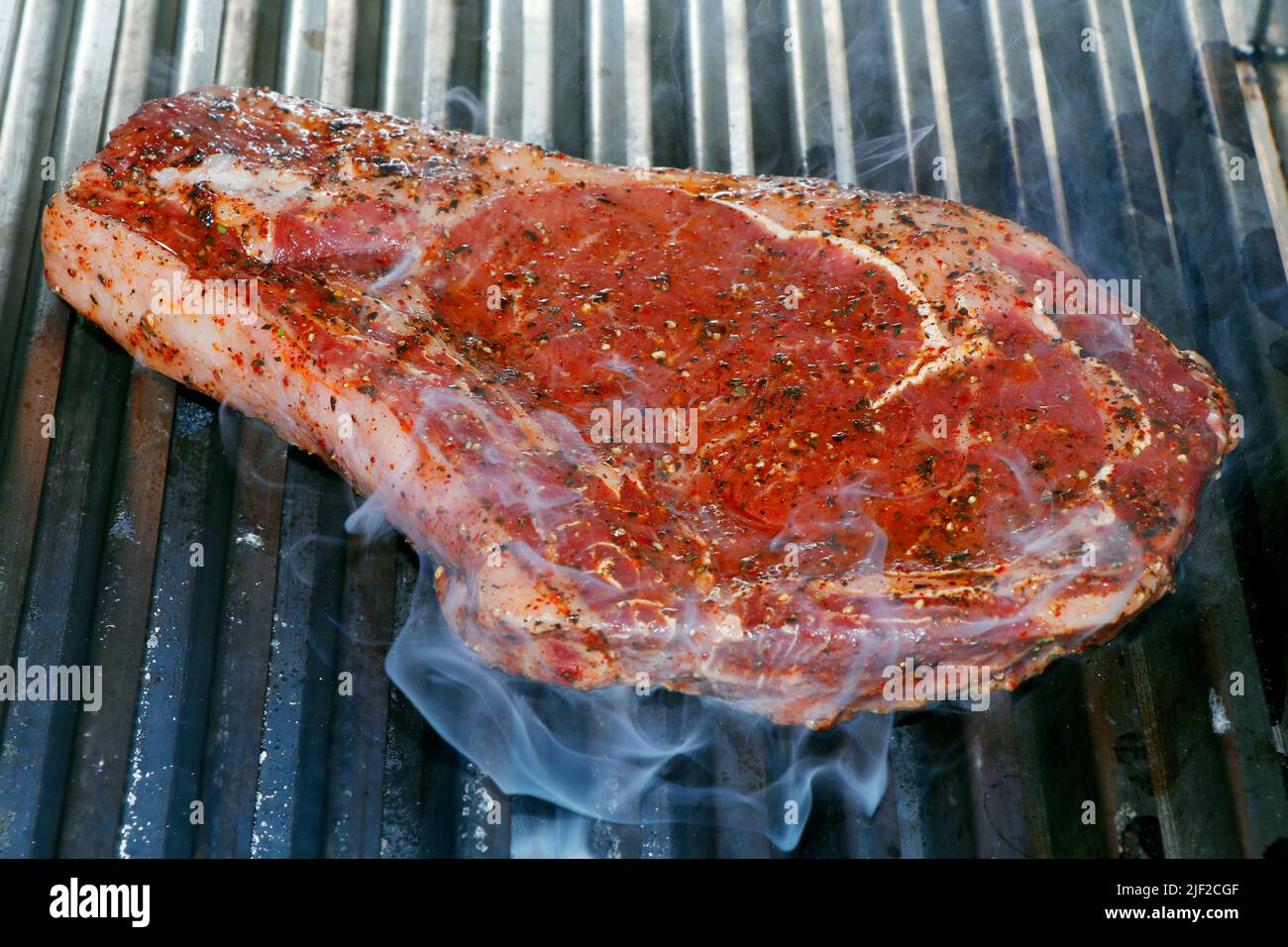 herb marinated american angus beef rib in a hot bbq grill Stock Photo ...
