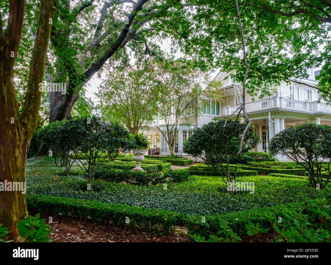 NEW ORLEANS, LA, USA - JUNE 27, 2022: Well manicured garden and side of mansion in Uptown neighborhood Stock Photo
