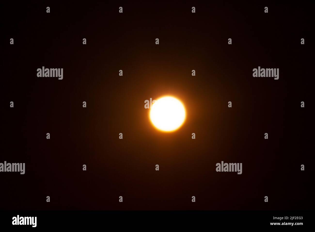 Bright blurred yellow spot. The sun on a black background Stock Photo