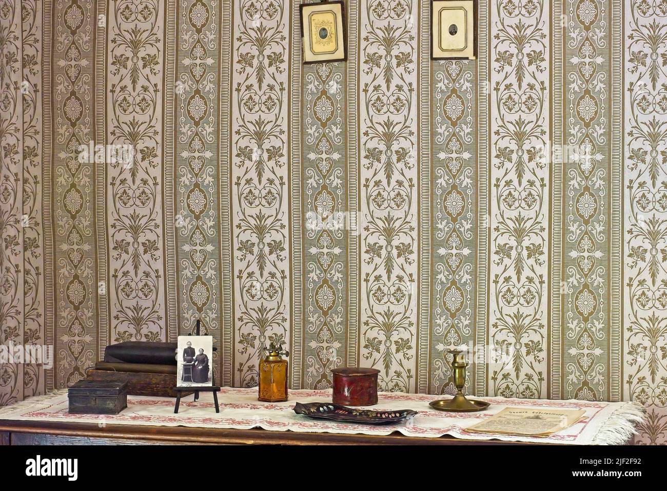 Photographs on table and wallpaper on the wall at Amuri Museum of historic Housing in Tampere Finland Stock Photo