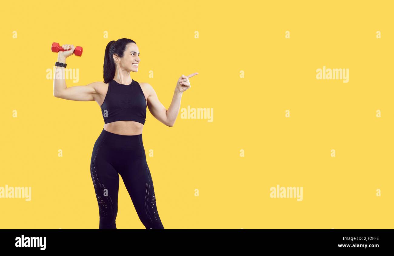 Smiling woman athlete point at good deal aside Stock Photo