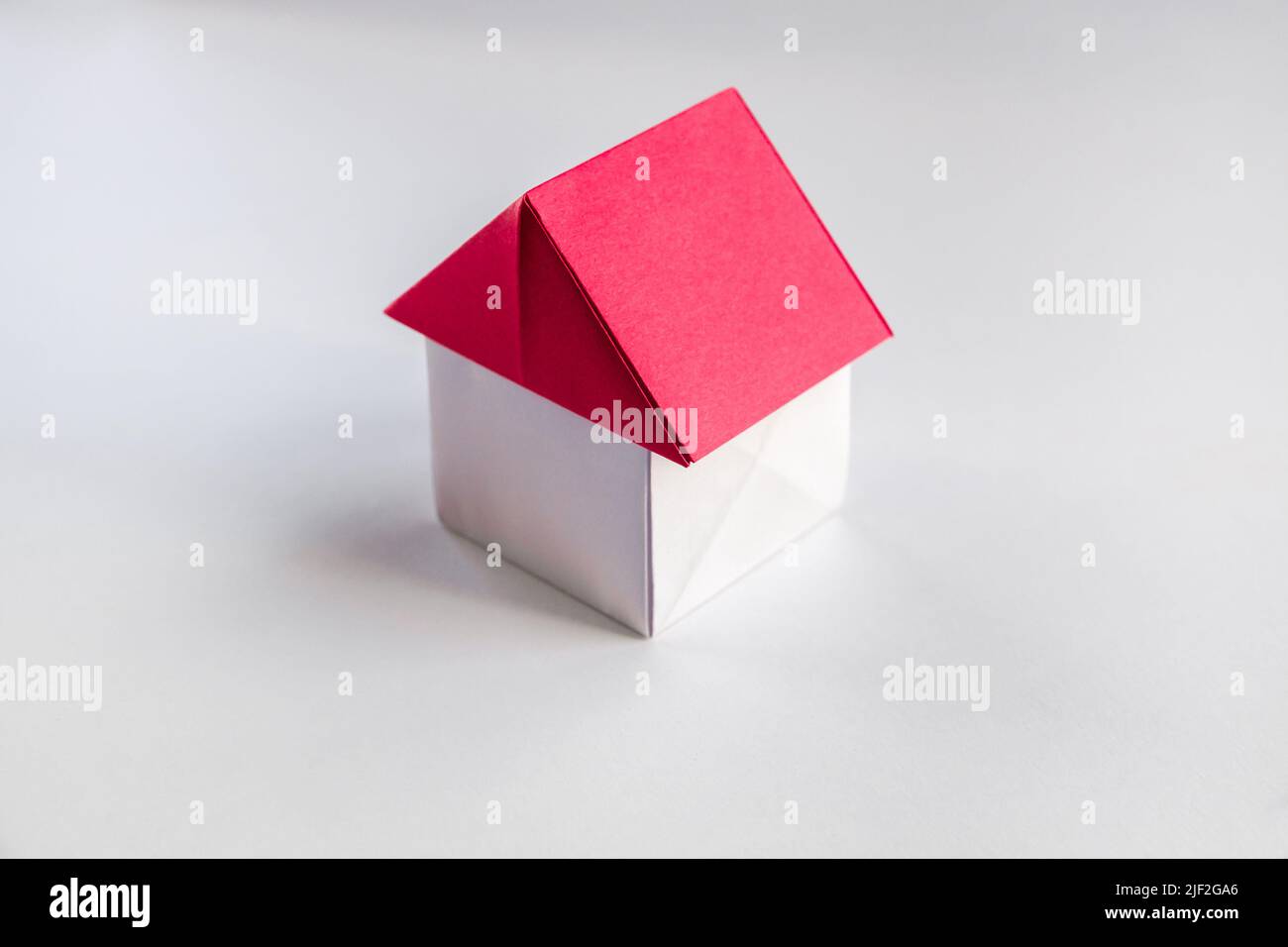White and red paper house origami isolated on a blank background. Stock Photo
