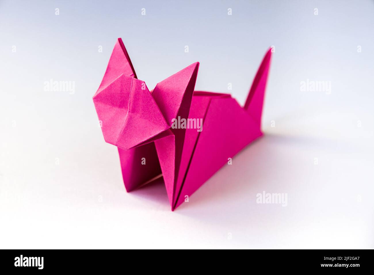 Pink paper cat origami isolated on a blank white background. Stock Photo