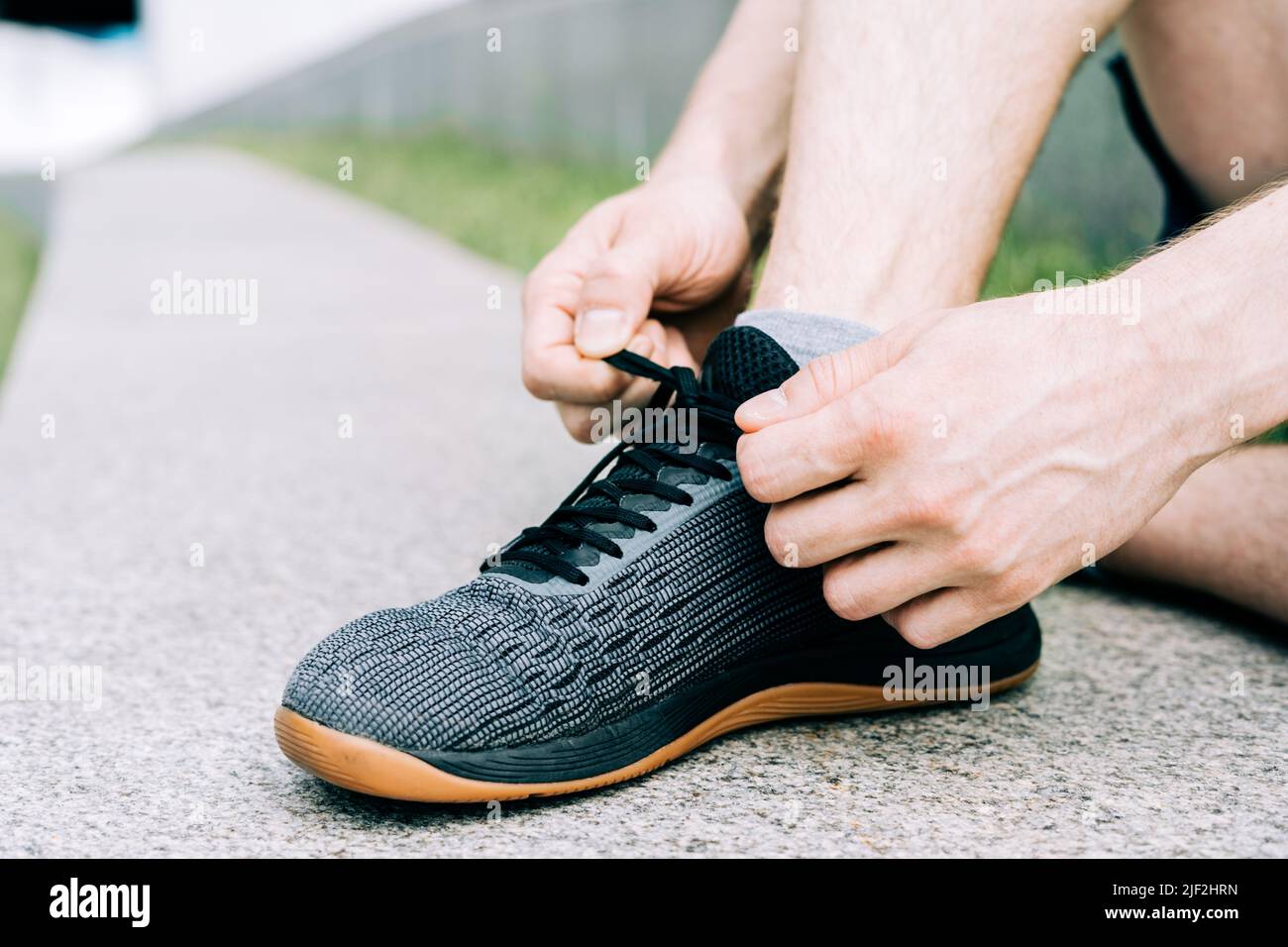 Close up sports man tying shoelace while running outdoors Stock Photo