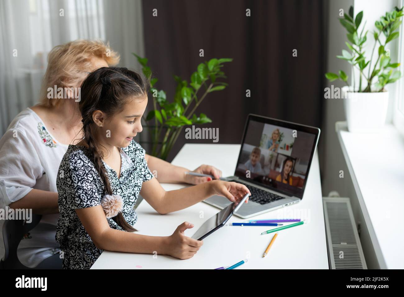 Grandmother and granddaughter using tablet and laptop Stock Photo - Alamy