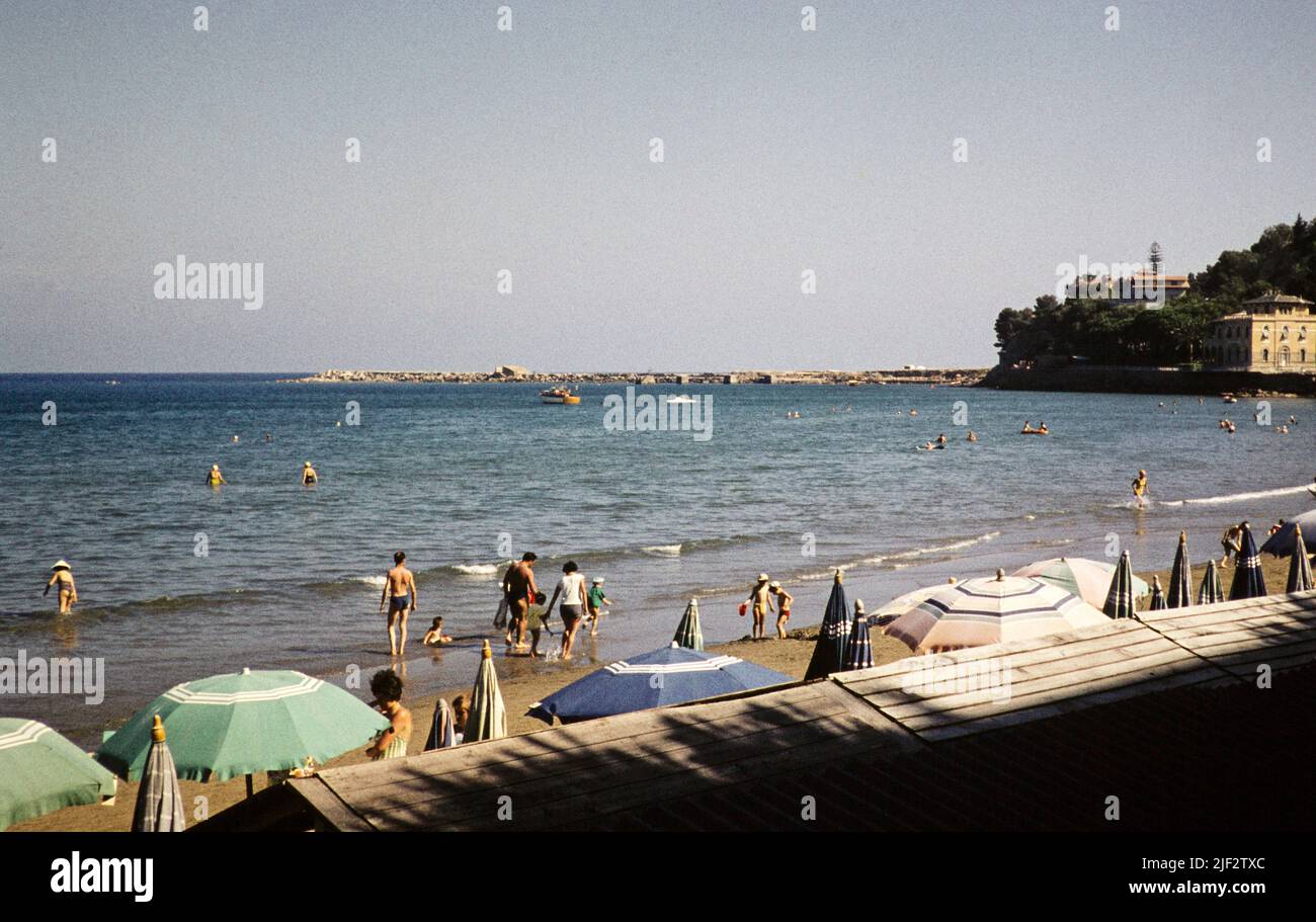 People at seaside on Mediterranean coast, Diano Marina,  Imperia, Liguria, Italy, July 1959 Stock Photo