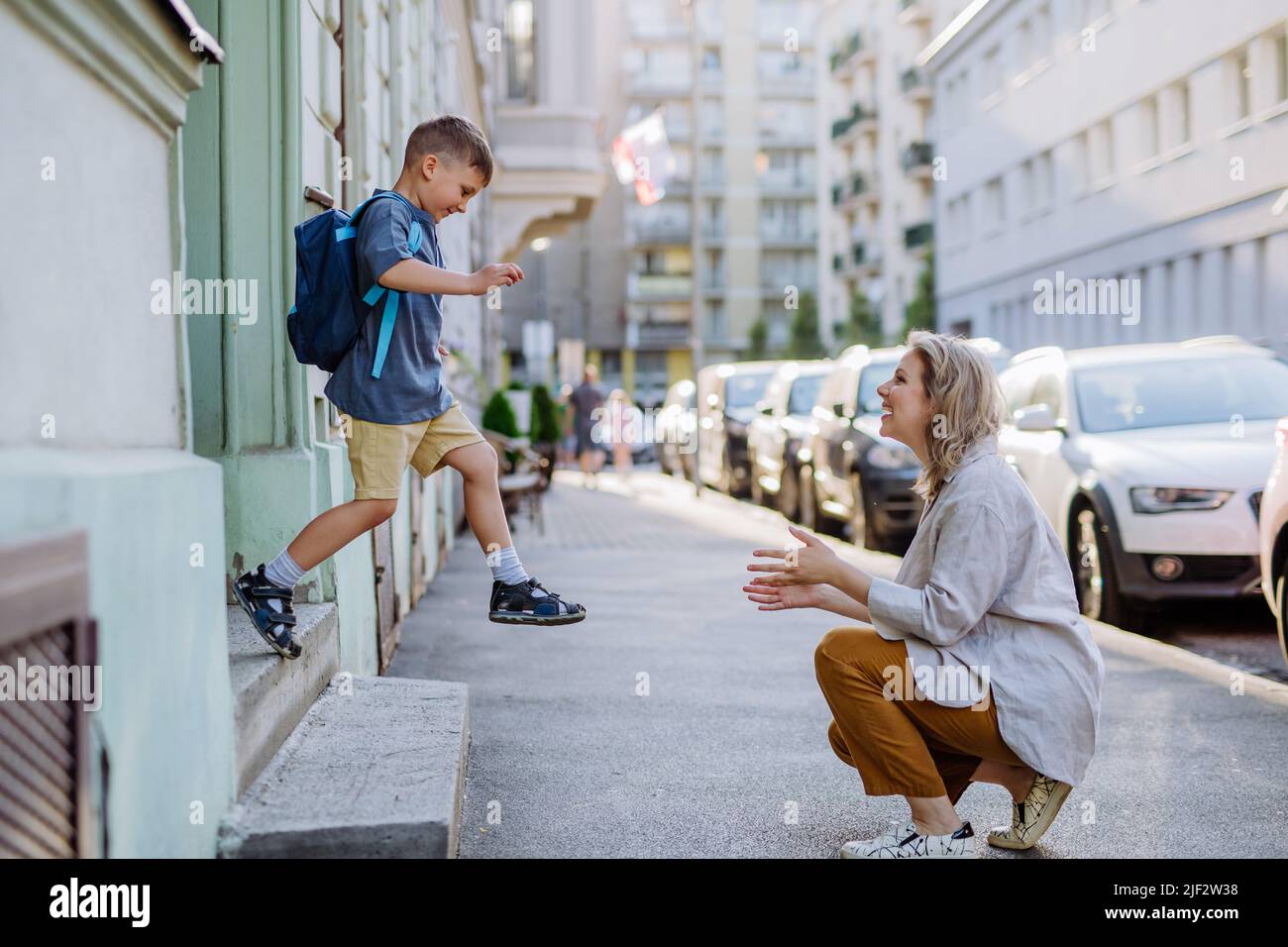 Young mother waiting for her little son on streetafter school, little