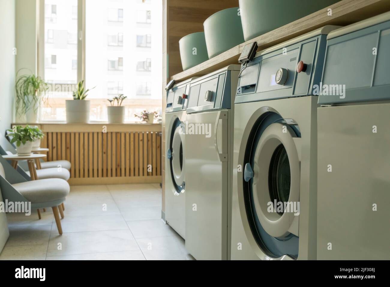 Laundry room interior. Washing machines and dryers in a bright home sunny laundry room. High quality photo Stock Photo