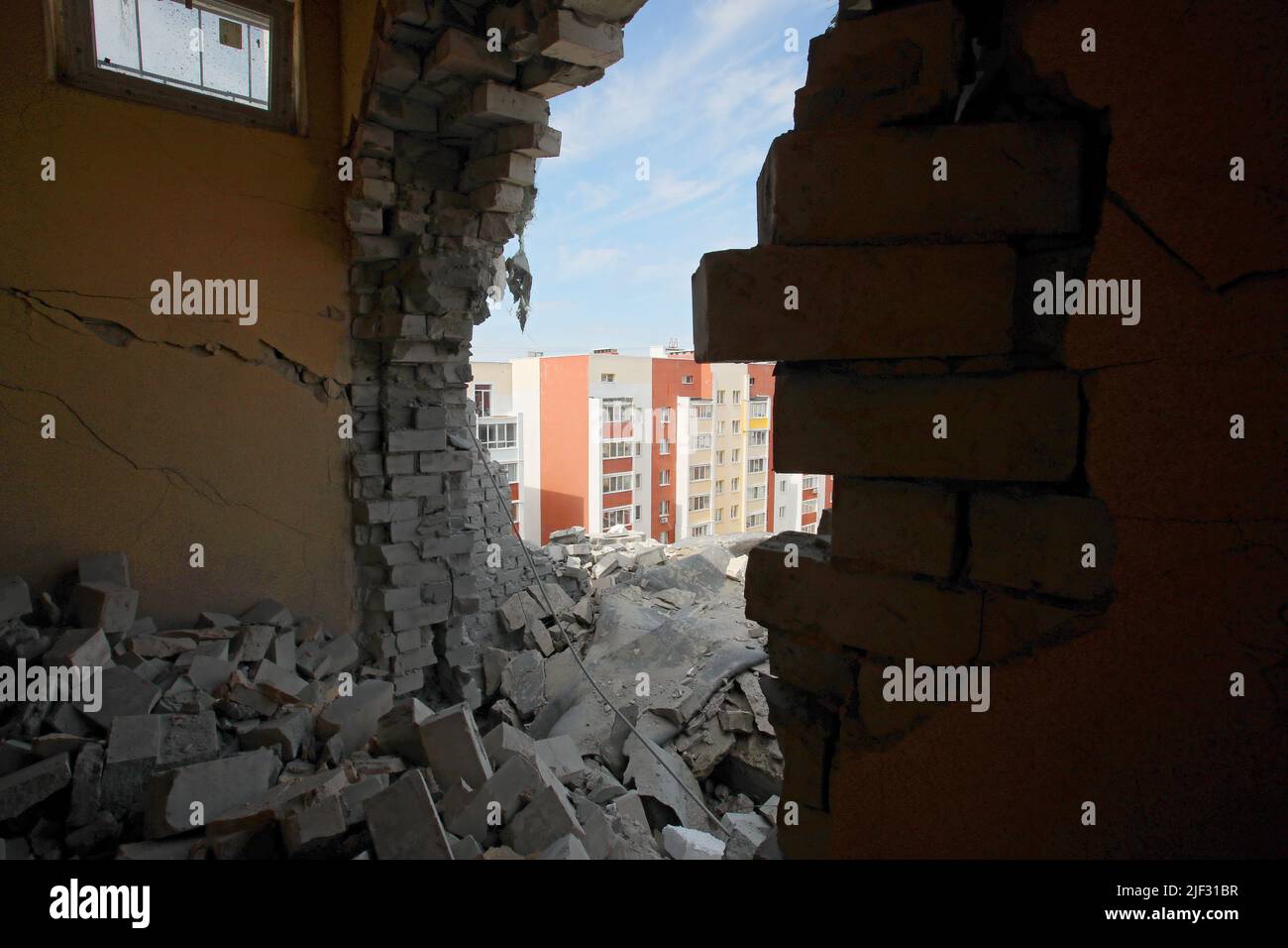 Non Exclusive: KHARKIV, UKRAINE - JUNE 26, 2022 - An apartment block is seen through a hole in the wall after the Russian troops shelled a northern ne Stock Photo