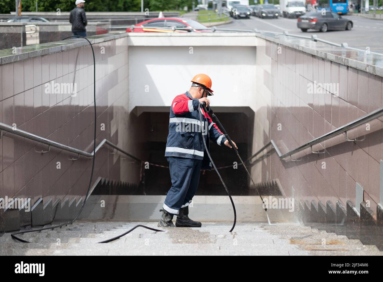 a worker washes tiles on the walls in an underpass in Moscow, Russia Stock Photo