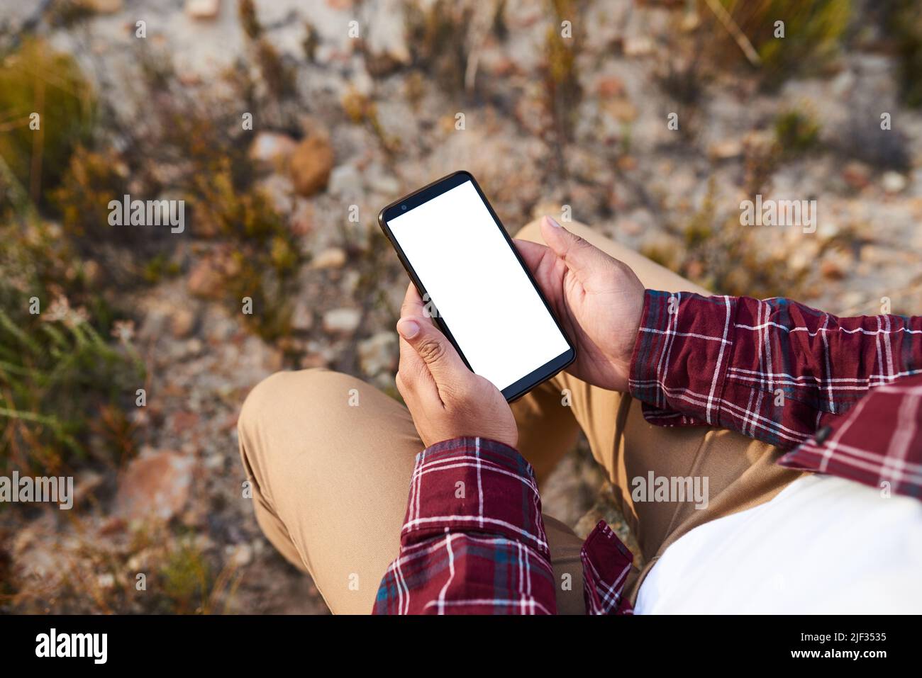An over the shoulder view of hiker with mobile device in wilderness, chroma key Stock Photo