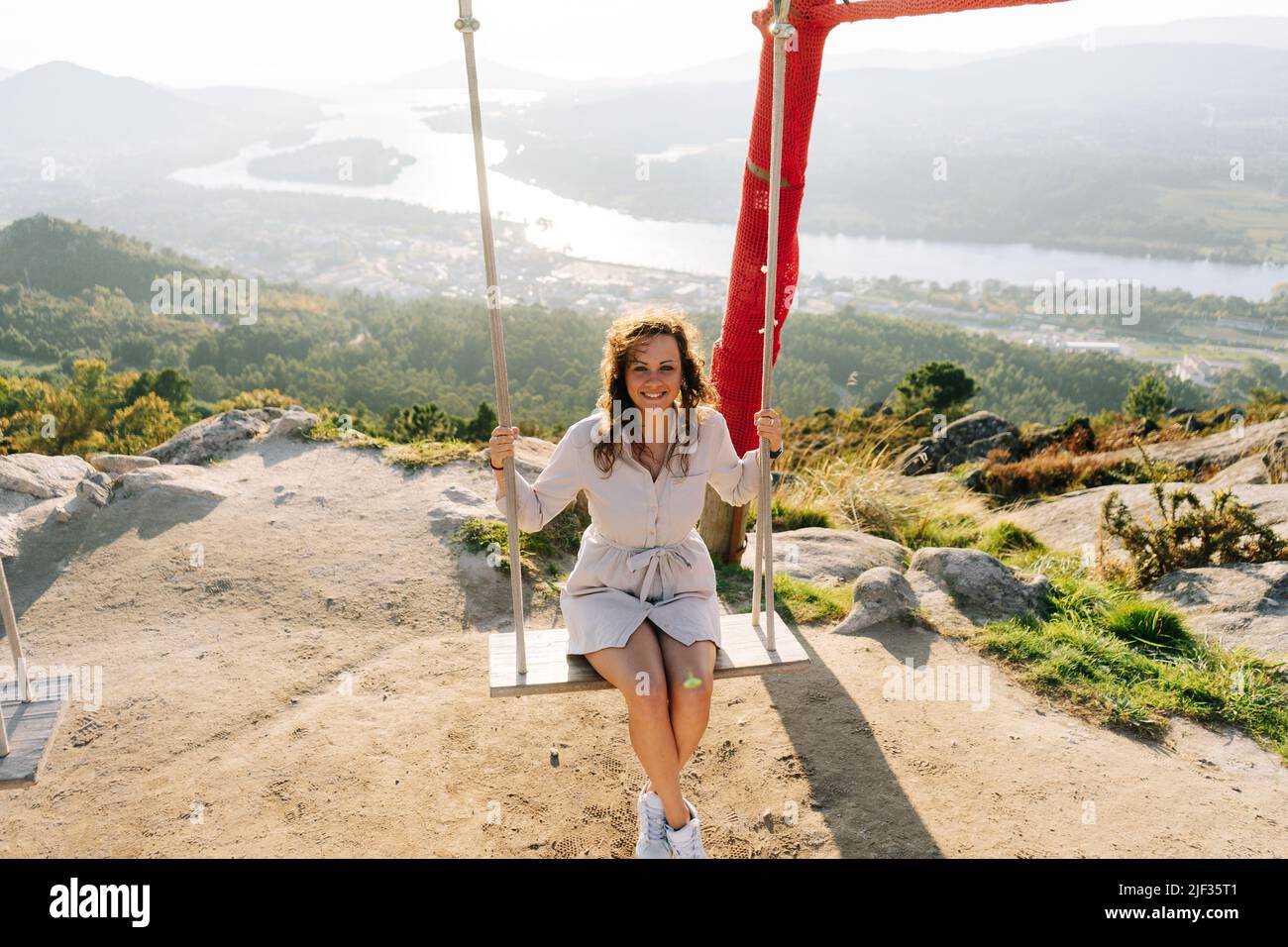 Young woman on a swing against a beautiful landscape in Galicia, Spain Stock Photo