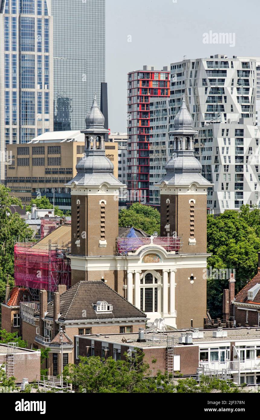 Rotterdam, The Netherlands, June 18, 2022: the two towers of Paradijskerk (Paradise Church) against the background of modern highrise in the city cent Stock Photo