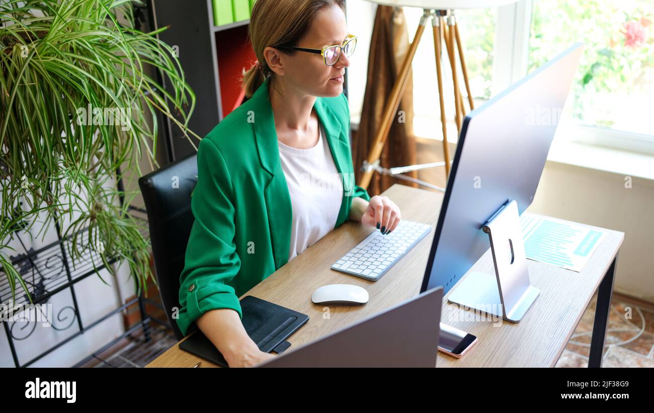 Smiling business woman working on compute in office Stock Photo