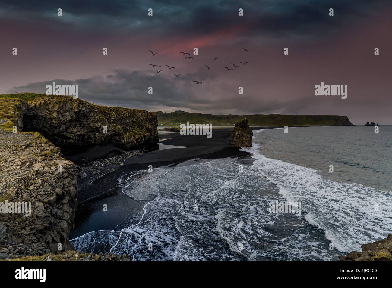 a magnificent view from the cliff of a black sand beach with a mighty ...