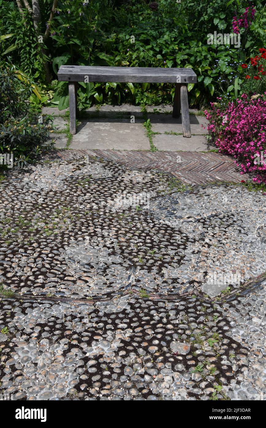 Bench on cobbled patio Stock Photo