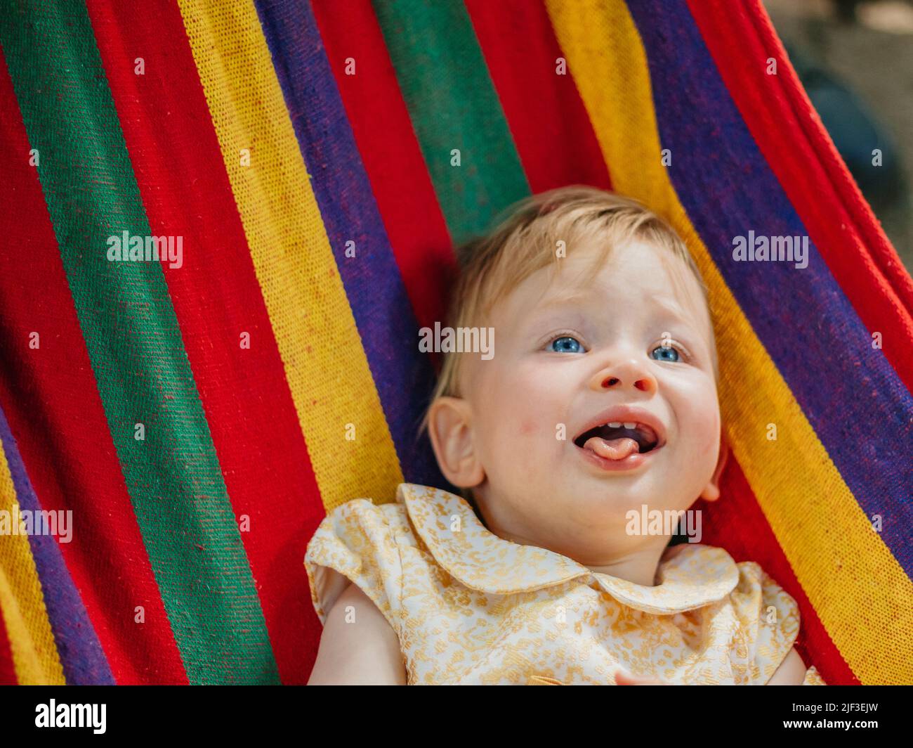 Child in a rainbow hammock Stock Photo