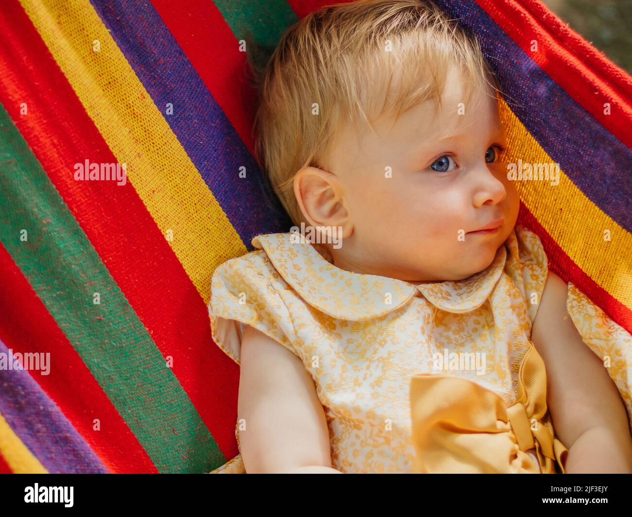 Child in a rainbow hammock Stock Photo