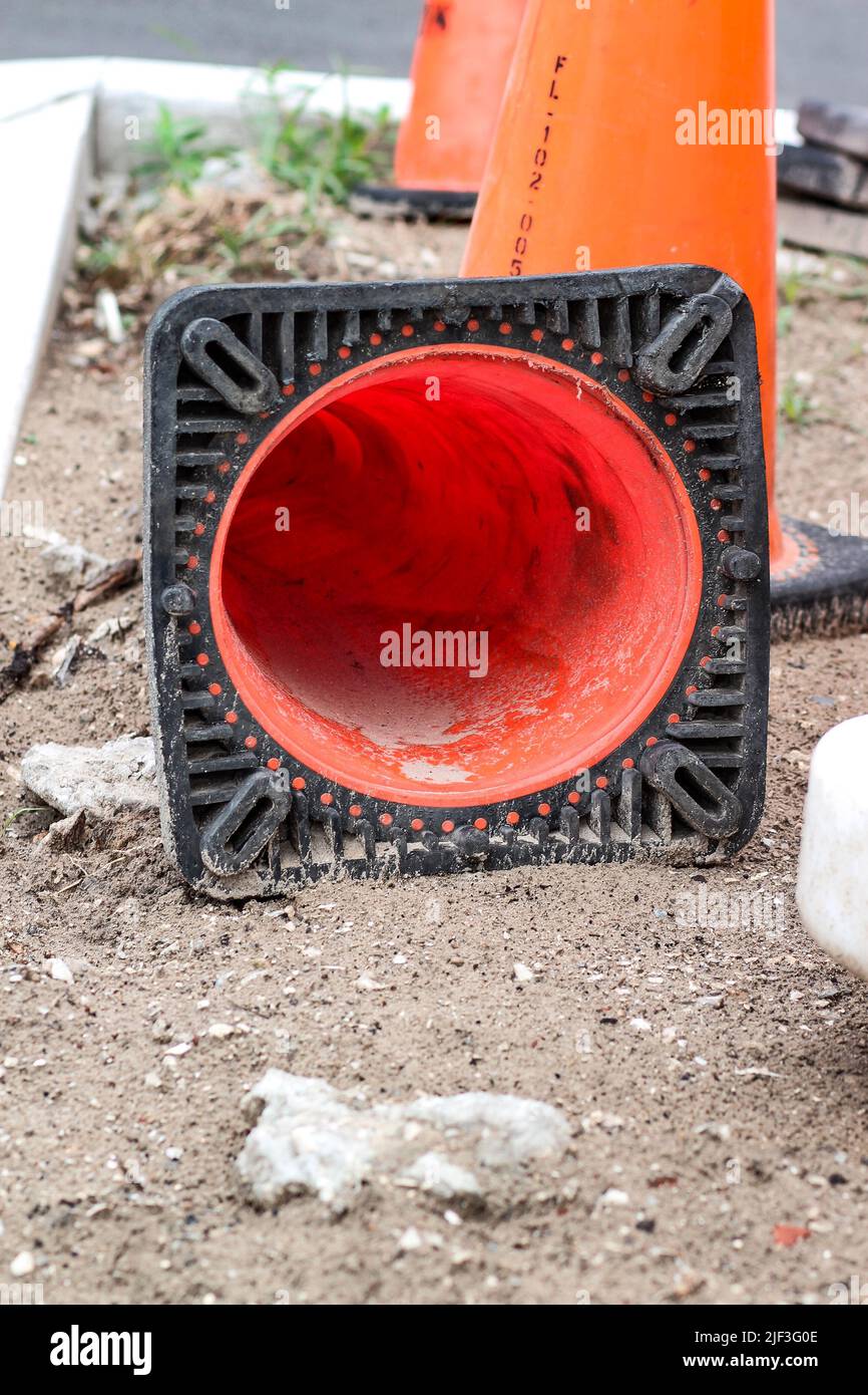 Vertical shot of three triangle orange traffic safety cones one fallen on the ground Stock Photo