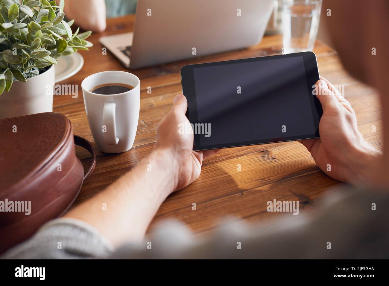 A man using his digital tablet while sitting at his table Stock Photo