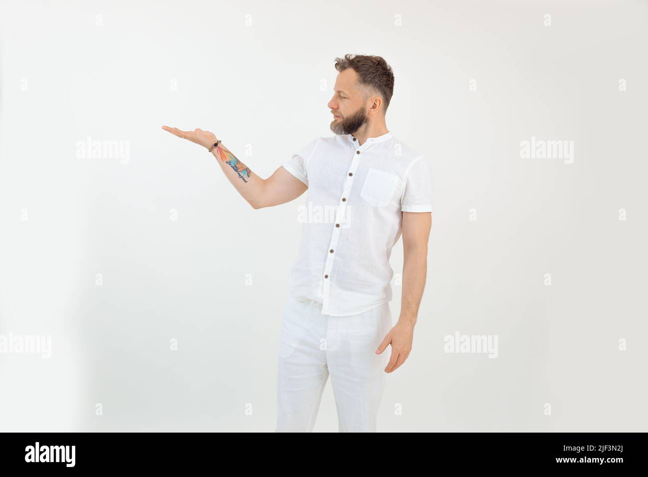 Handsome bearded confident, serious tattooed businessman in uniform on white backview. Showing place for text or product Stock Photo