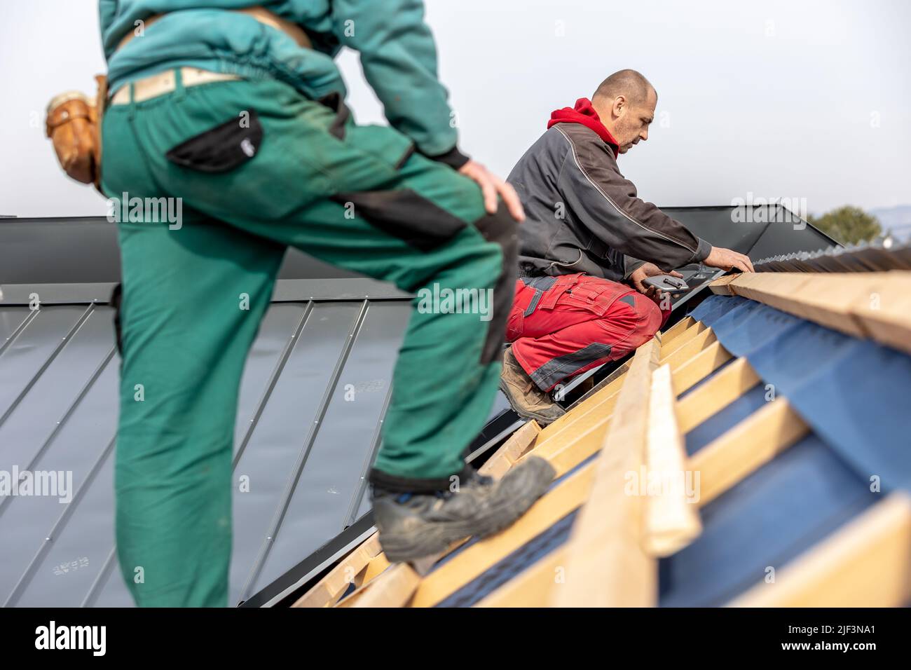 Craftsman or construction worker install a new roof, roofing tools, new metallic roof or metal