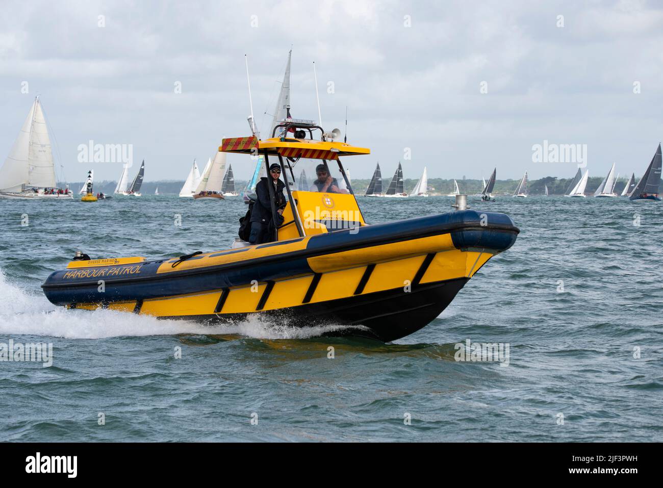 The Cowes Harbour Commission harbour patrol yellow RIB returns from supervising the start of the Isle of Wight Sailing Club's Round The Island Race Stock Photo