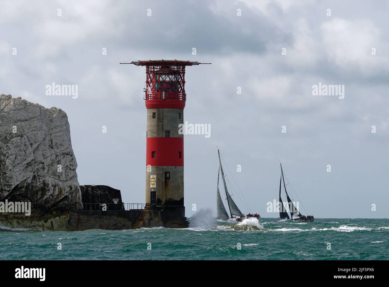 Two sailing yachts, Baraka and Dark'N'Stormy fight for position as they round The Needles lighthouse at the Western end of the Isle of Wight Stock Photo
