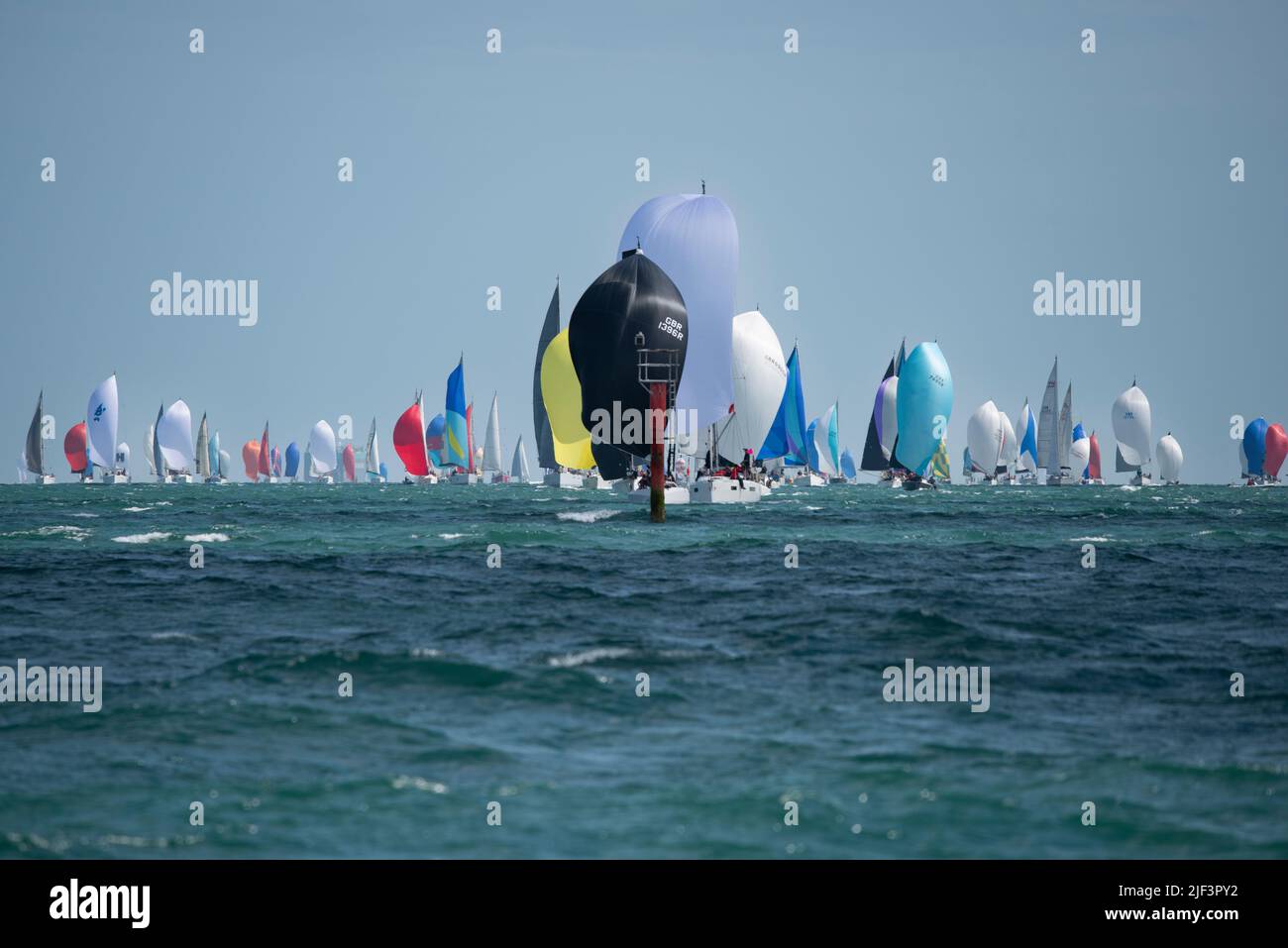 A huge gathering of sailing yachts competing in the Isle of Wight Sailing Club's annual Round The Island Race approach the Red Pile marking Ryde sands Stock Photo
