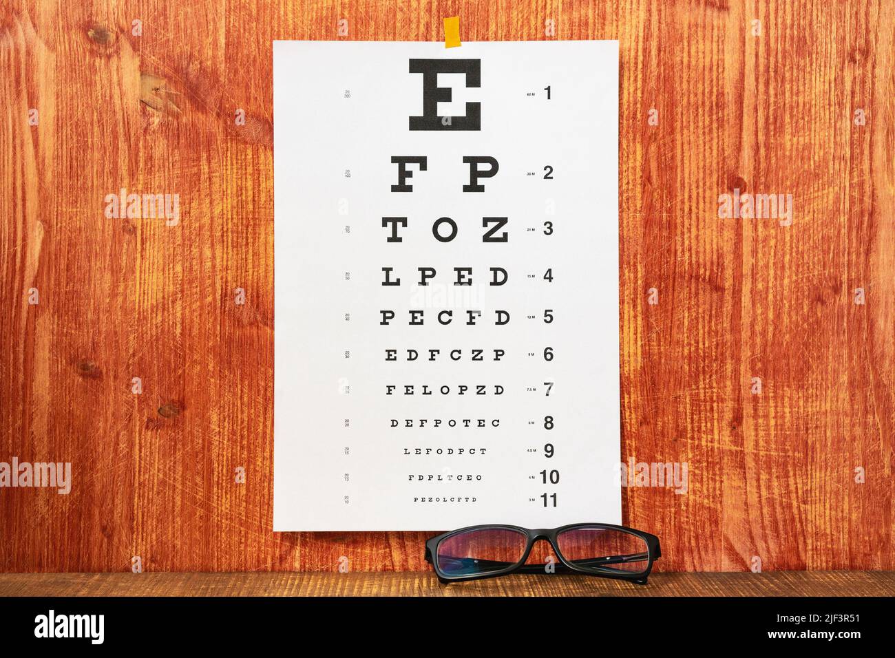 Eye Chart and Glasses on the wooden table.Eyesight Eye Care. Stock Photo