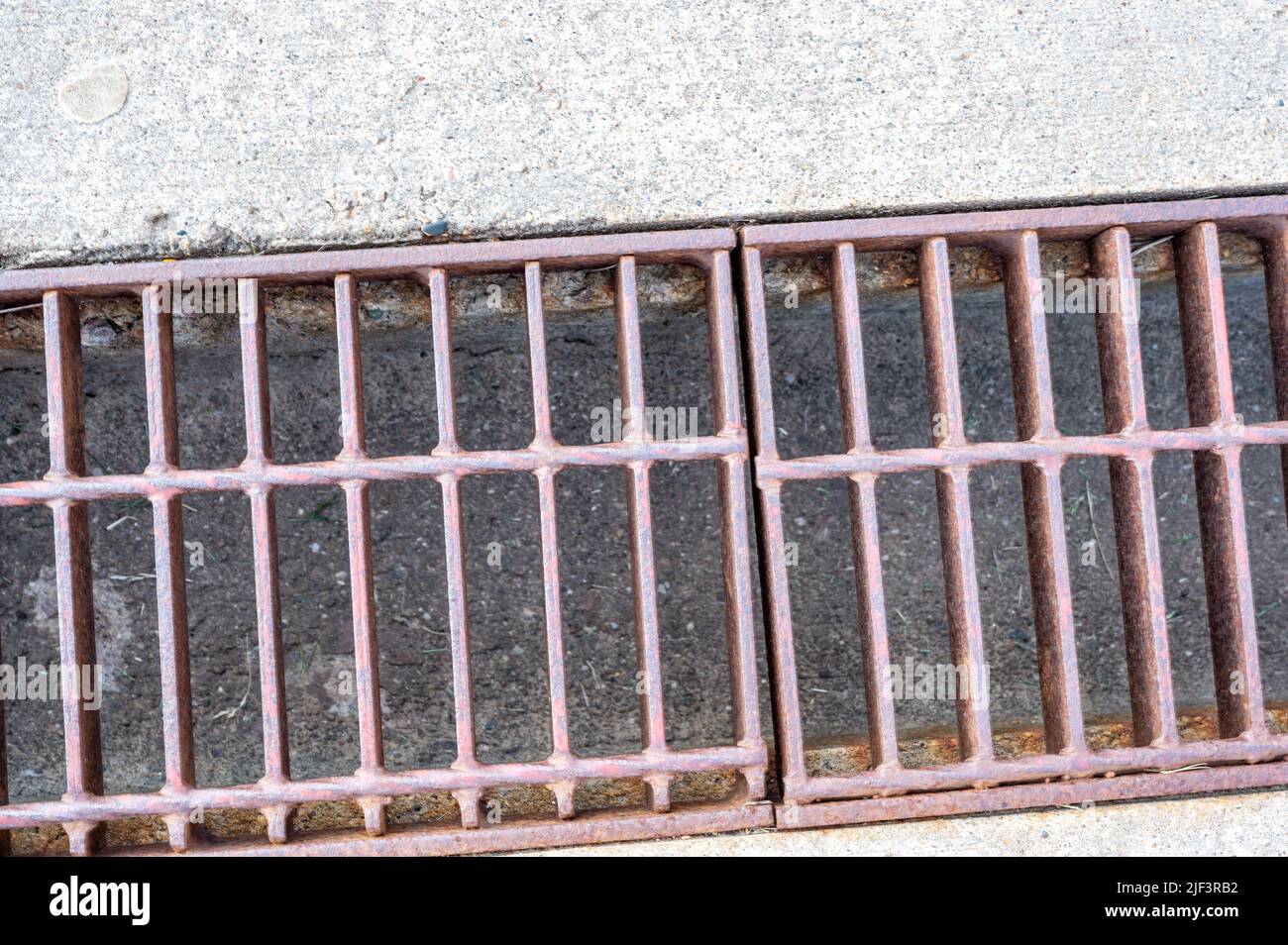 Grate over a stormwater trench in a concrete slab.  Stock Photo
