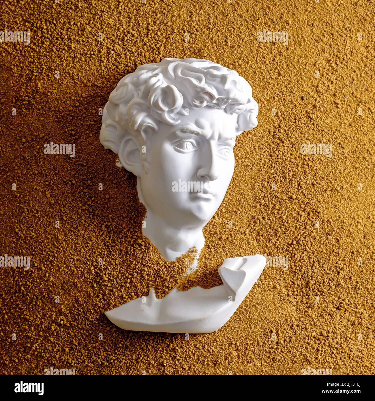 Gypsum David head in dune or sand. Creative concept excavation story and texture effect. Stock Photo