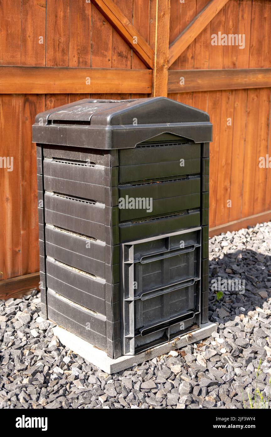Black plastic compost bin in urban garden with fence Stock Photo Alamy