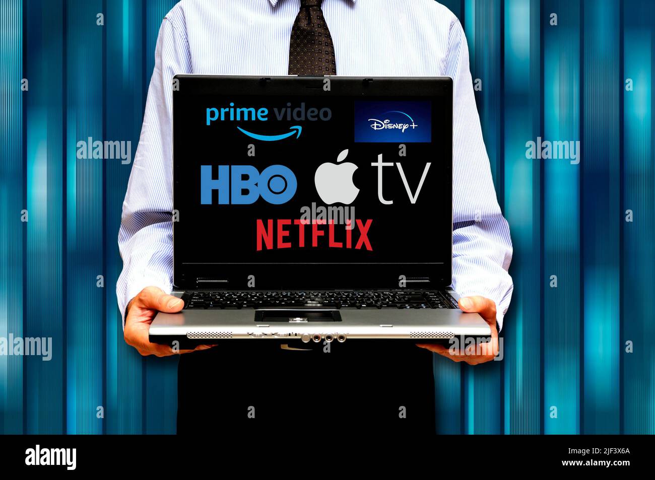 man with laptop and various streaming video services logo on screen Stock Photo
