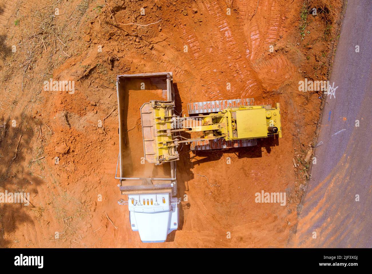 Using heavy construction equipment, a excavators loads earth into to