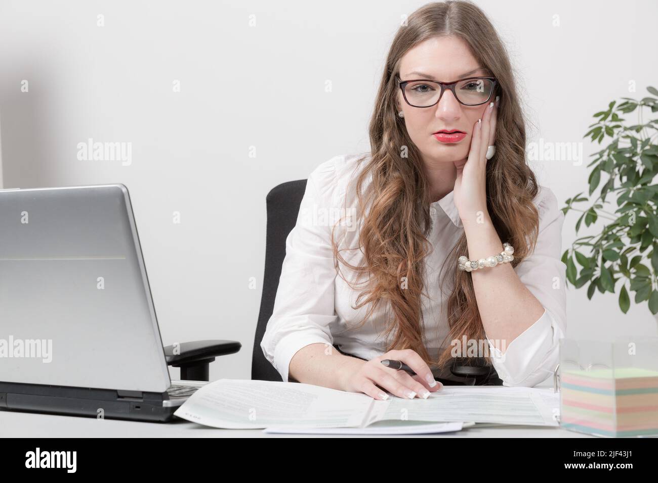 young business woman is working with computer and papers at desk Stock Photo