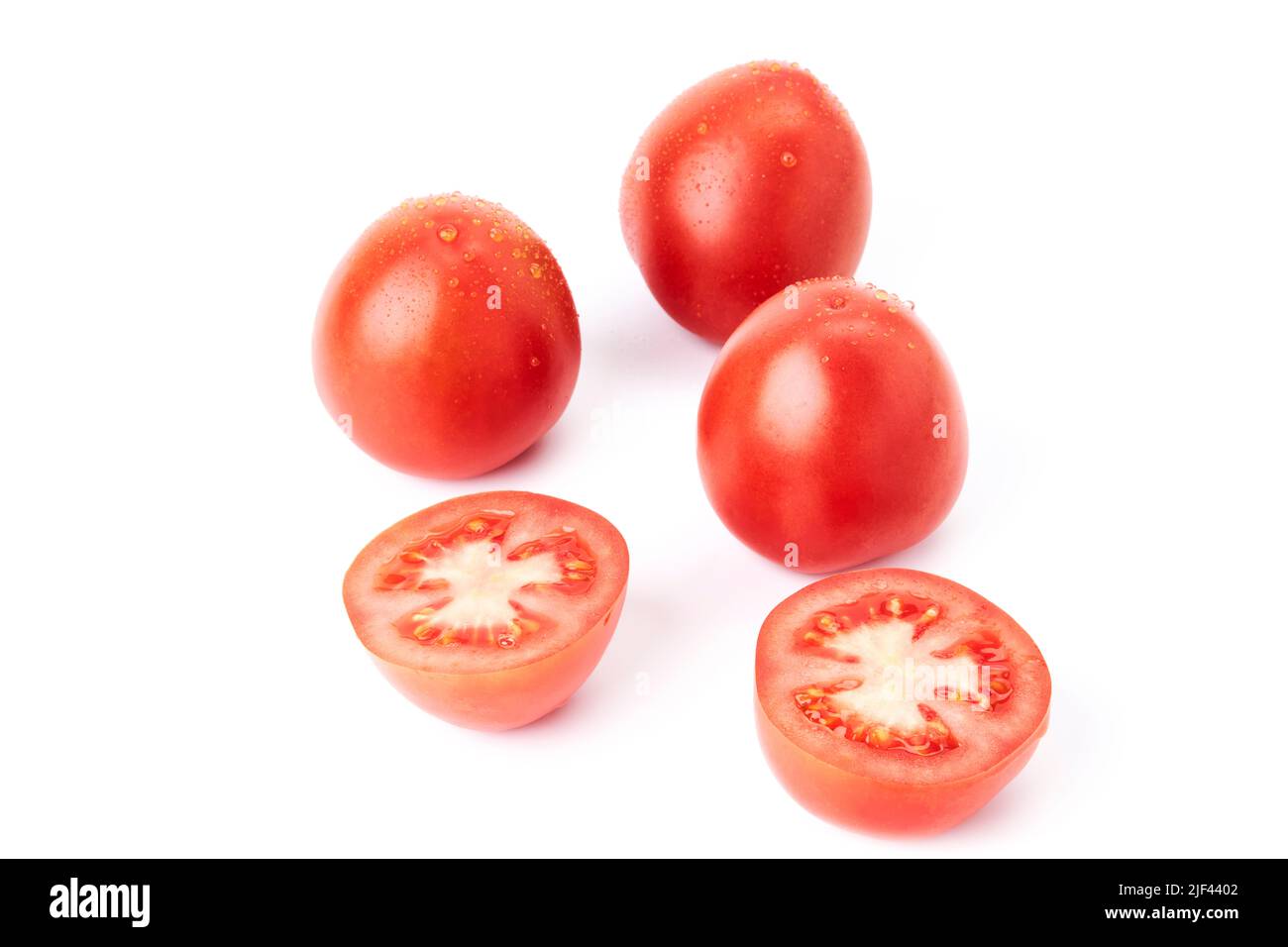 Three red ripe tomatoes soaked in water together with a tomato cut in half. Organic food. Vegetarian and healthy food Stock Photo