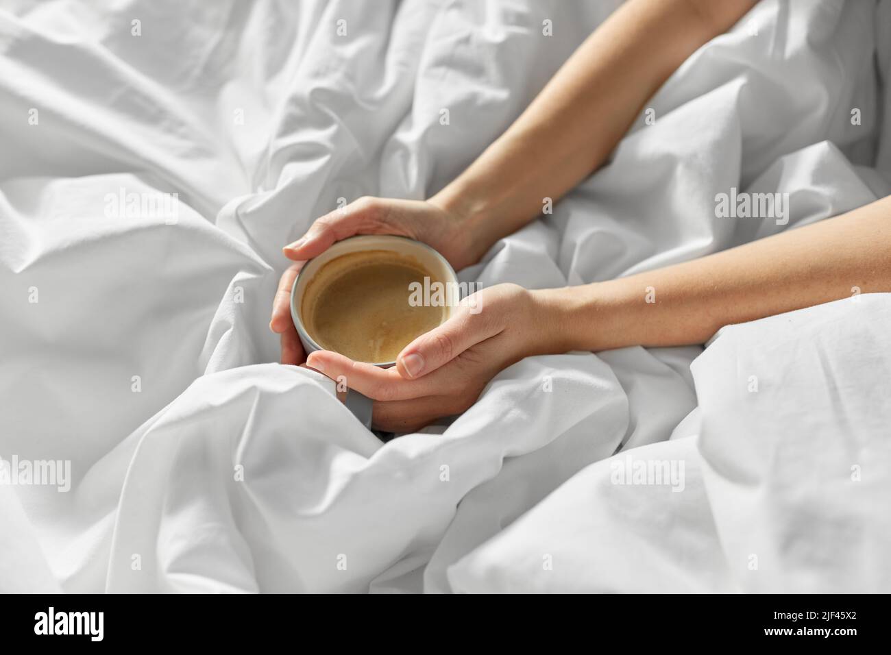 hands of woman with cup of coffee in bed Stock Photo - Alamy