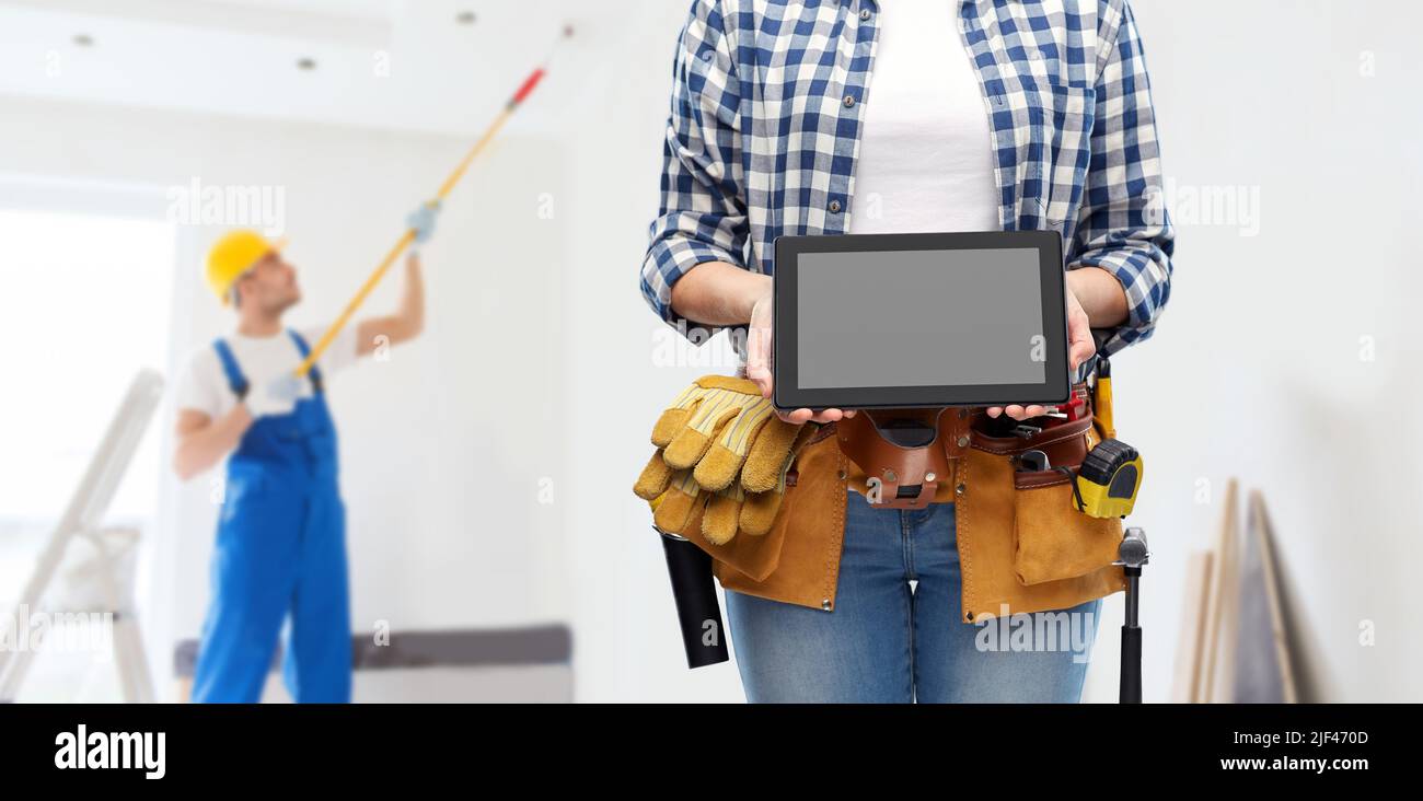 woman builder with working tools showing tablet pc Stock Photo