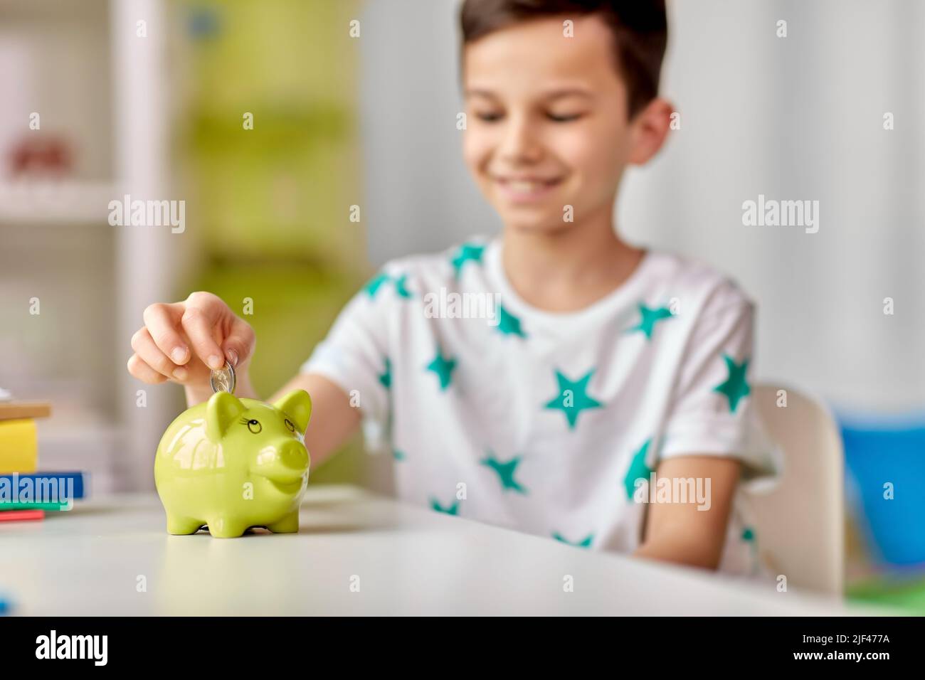 little boy putting coin into piggy bank at home Stock Photo - Alamy