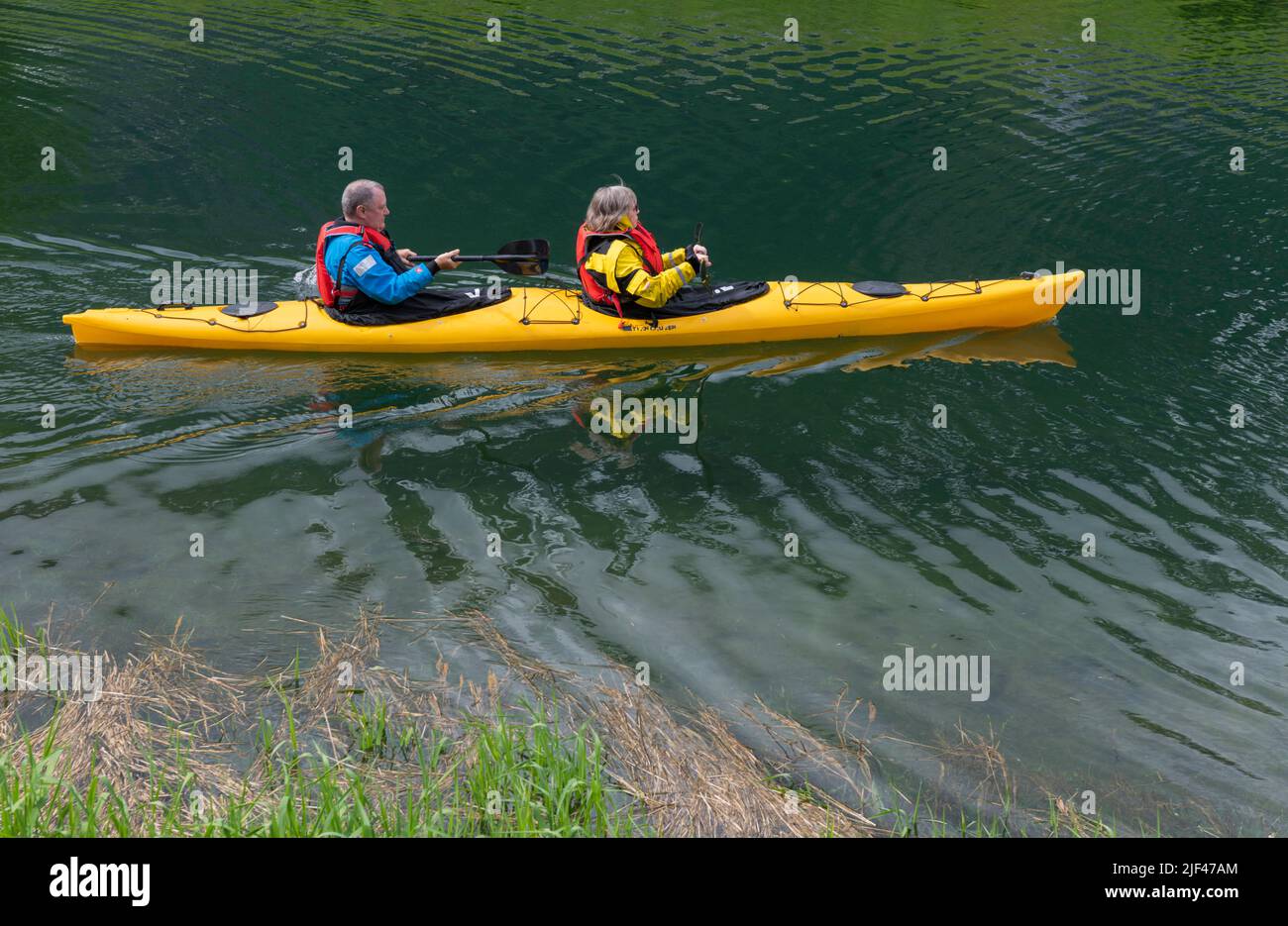 Tourists in yellow kayaks, Norwegian Fjords, Olden, Norway Stock Photo