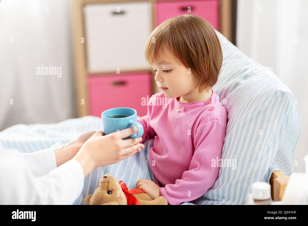 Hospital Tea doctor giving hot tea to sick little girl in bed Stock Photo - Alamy