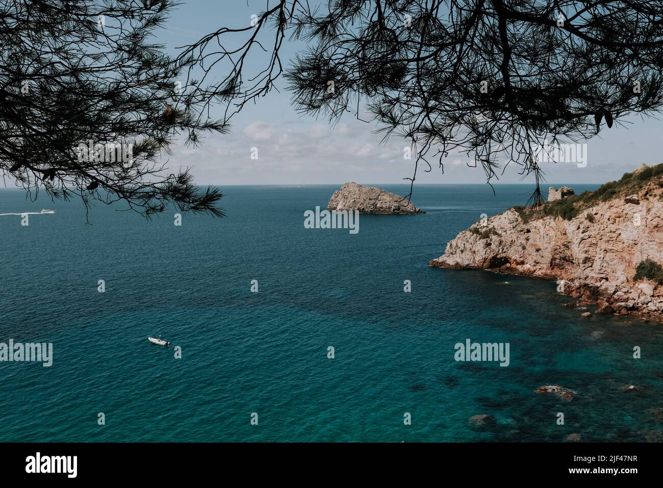 Eine Küste in Italien. Türkis blaues Meer. Kleines Boot im Wasser Stock Photo