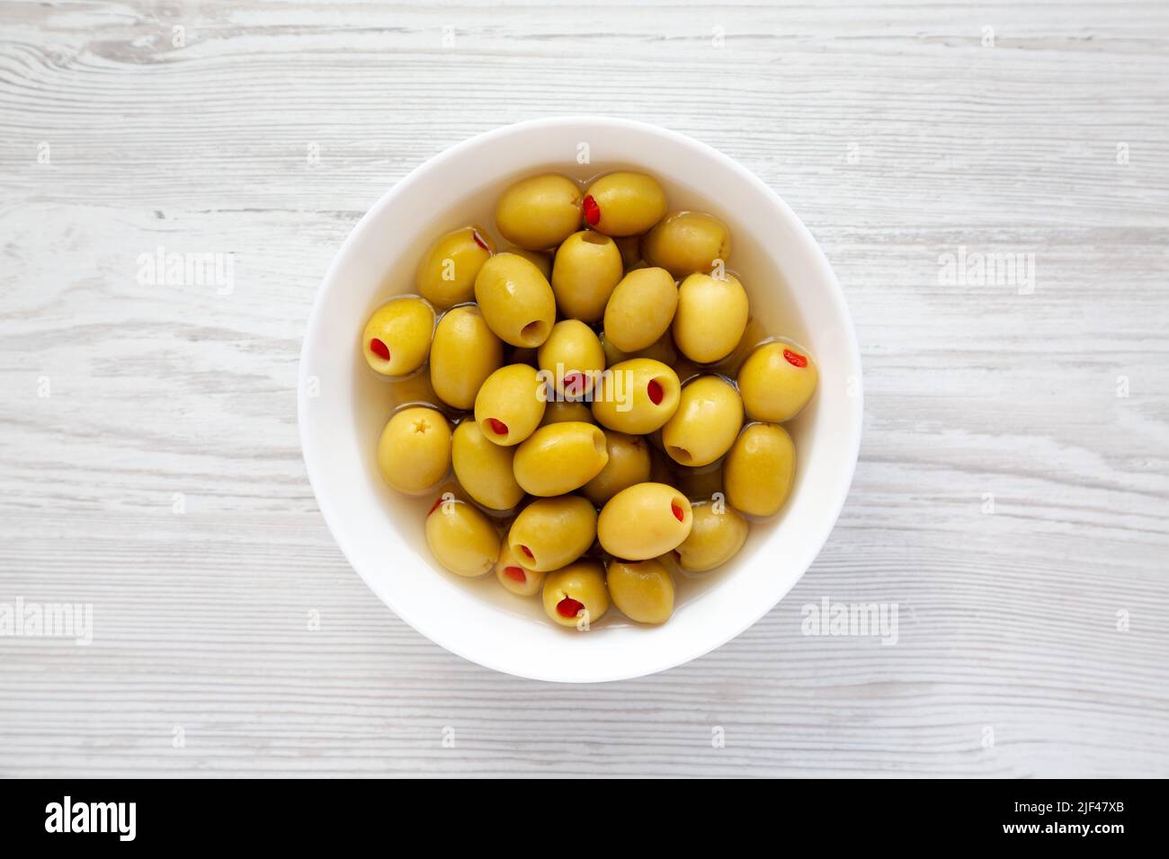 Marinated Green Olives with Pimento Peppers in a Bowl, top view. Flat