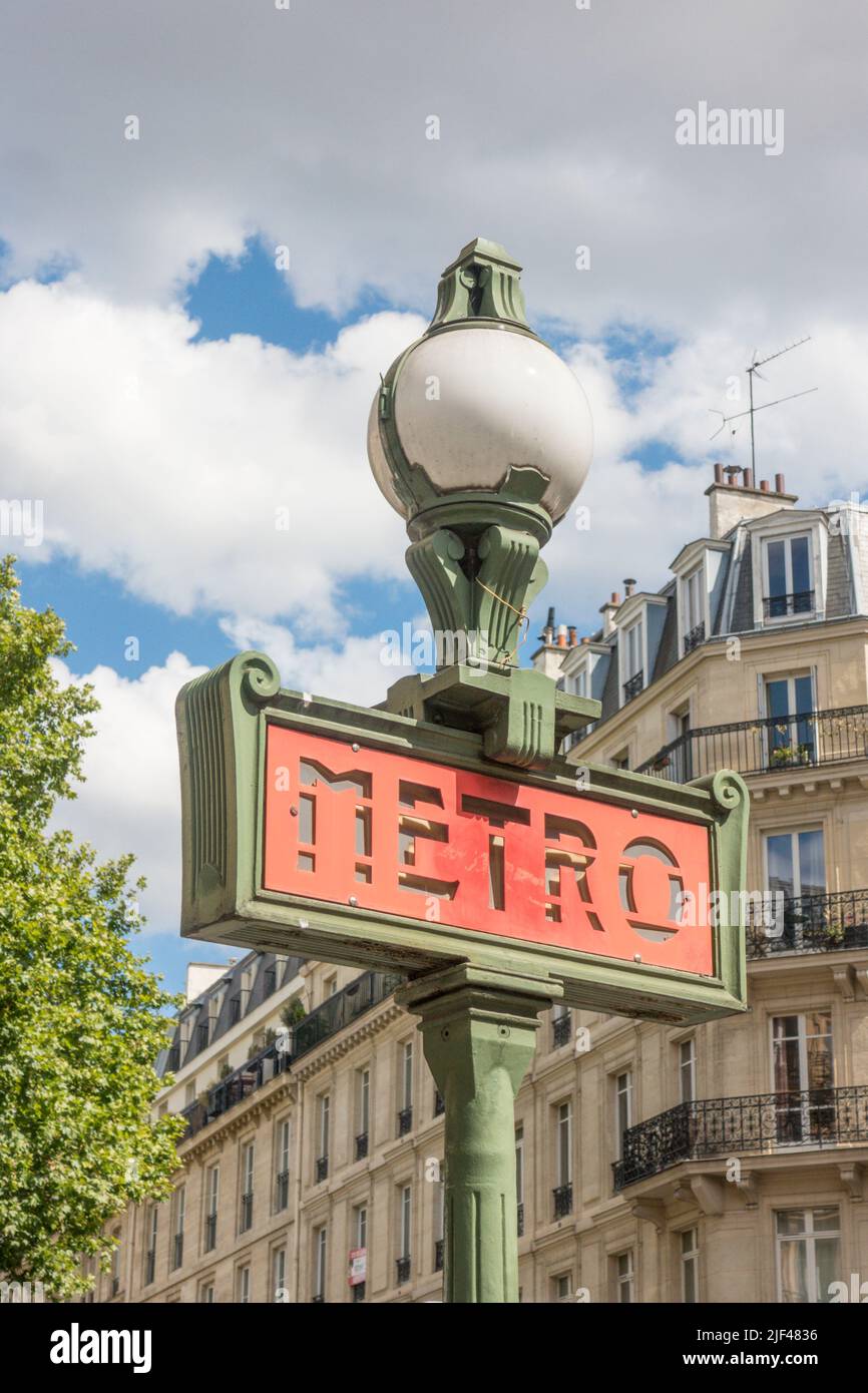 Vintage metro sign with Parisian houses in background. Paris, France. Stock Photo