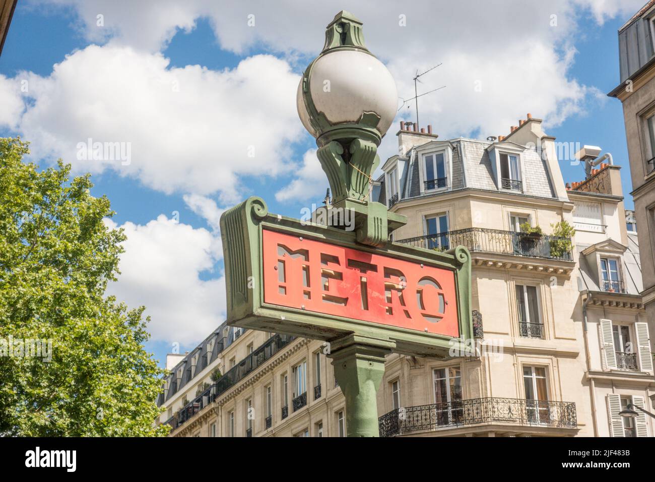 Vintage metro sign with Parisian houses in background. Paris, France. Stock Photo