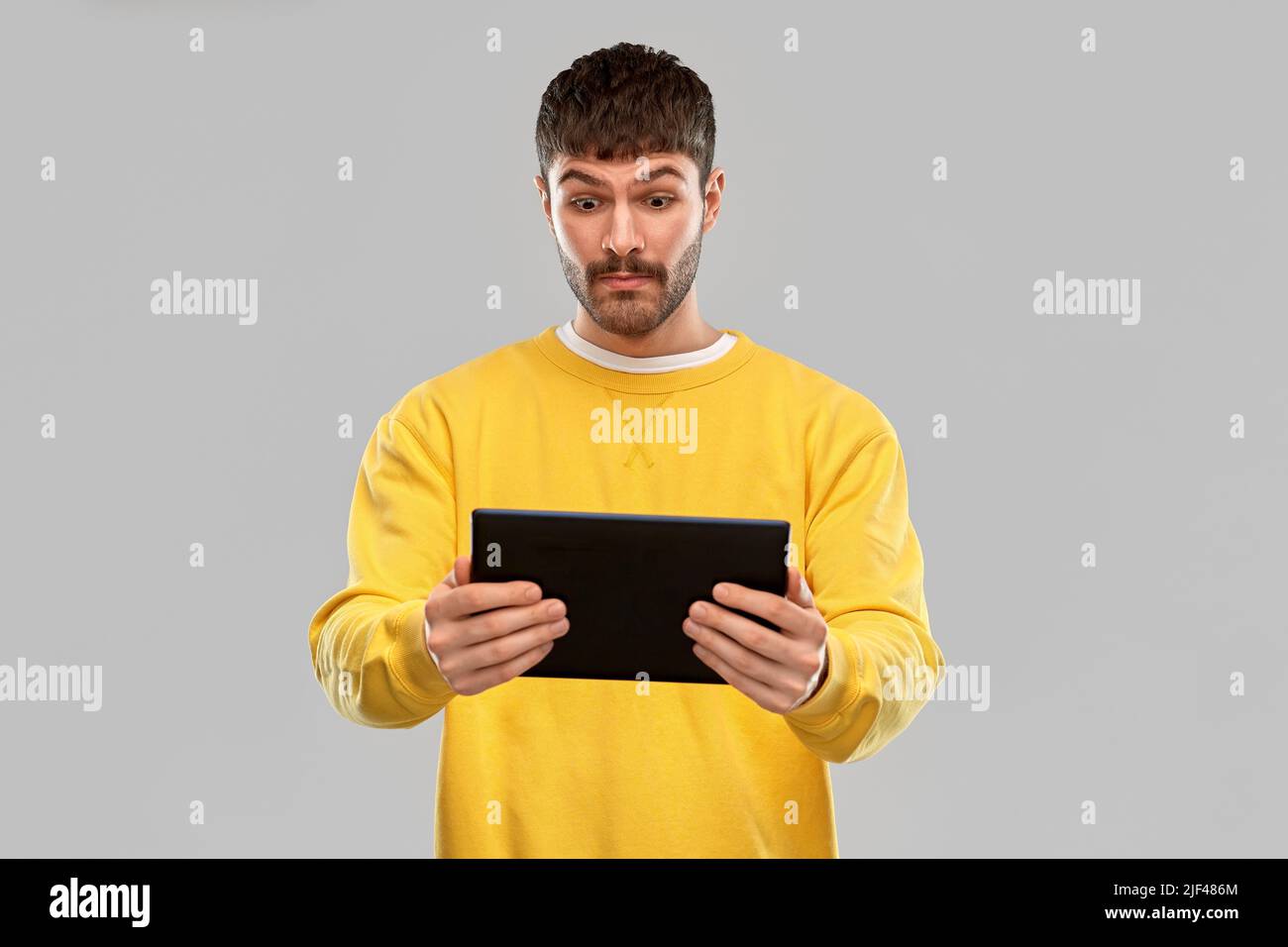 surprised young man with tablet pc computer Stock Photo