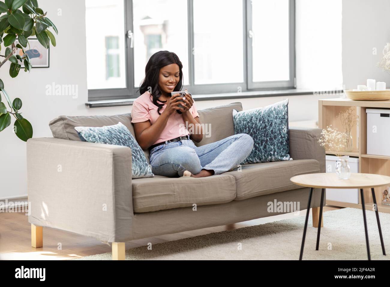 happy african woman drinking tea or coffee at home Stock Photo - Alamy